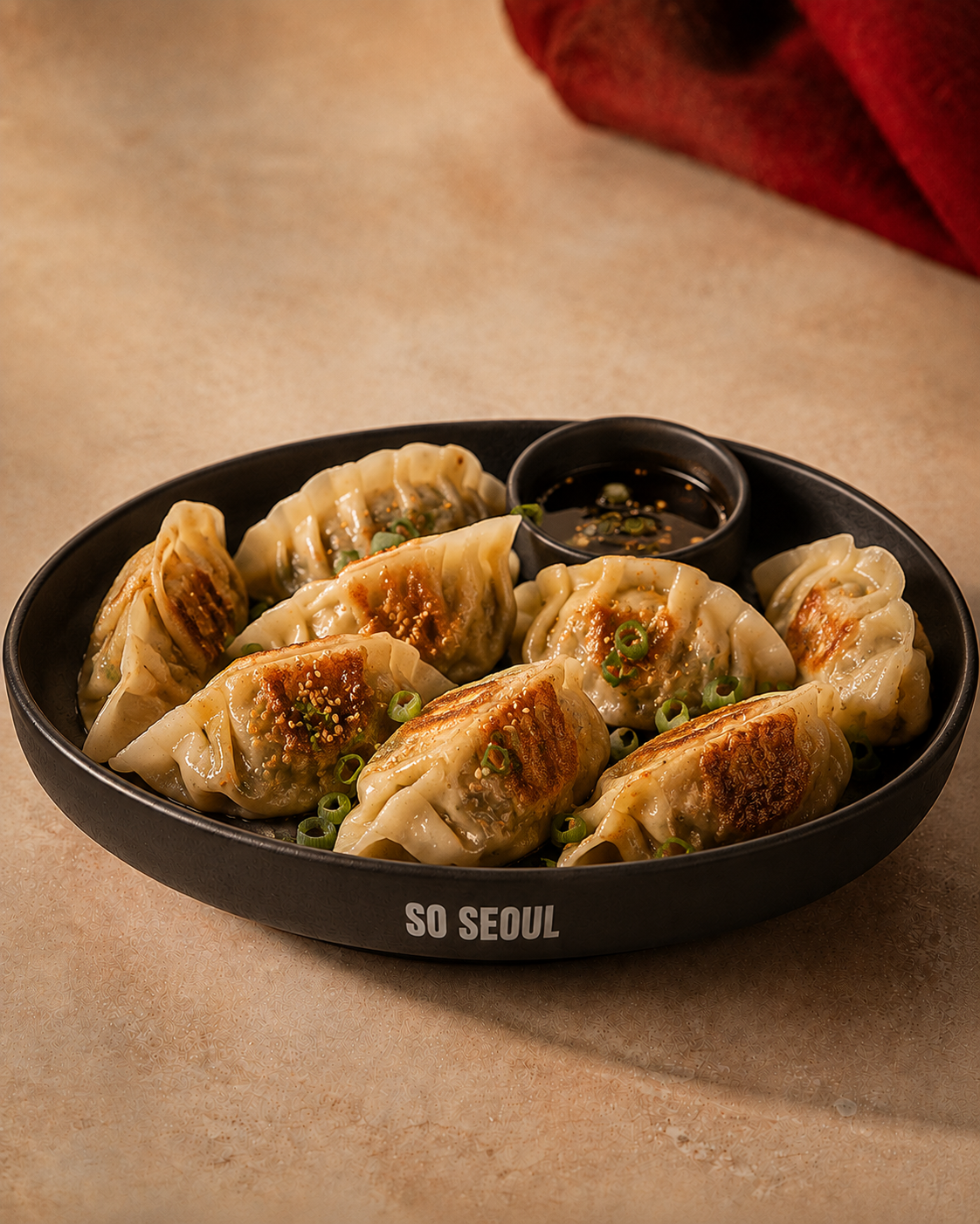 A So Seoul plate of pan-cooked Korean mandu with dipping sauce.